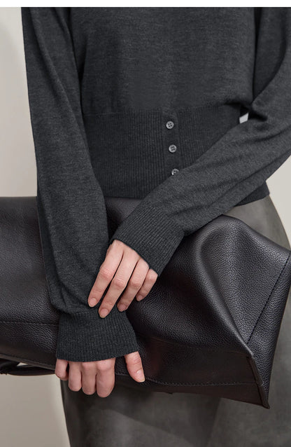 Nahaufnahme: Grauer Strickpullover mit Knöpfen und geripptem Bündchen