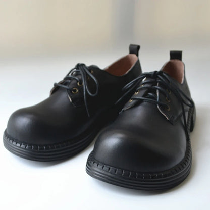 Herrenlederschuhe mit Schnürung, runder Schuhspitze, dunkle Lederoberfläche, flache Sohle