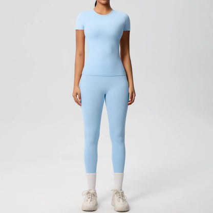 Hellblaues Sport-Set mit Crop-Top und Leggings, enganliegend, 3/4-Länge, weißer Abschluss.