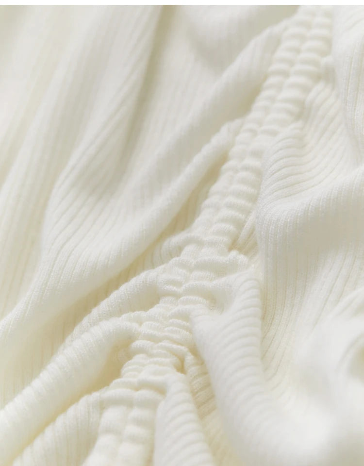 Fein geripptes Strickmuster am cremefarbenen Pullover, detailreiche Oberfläche