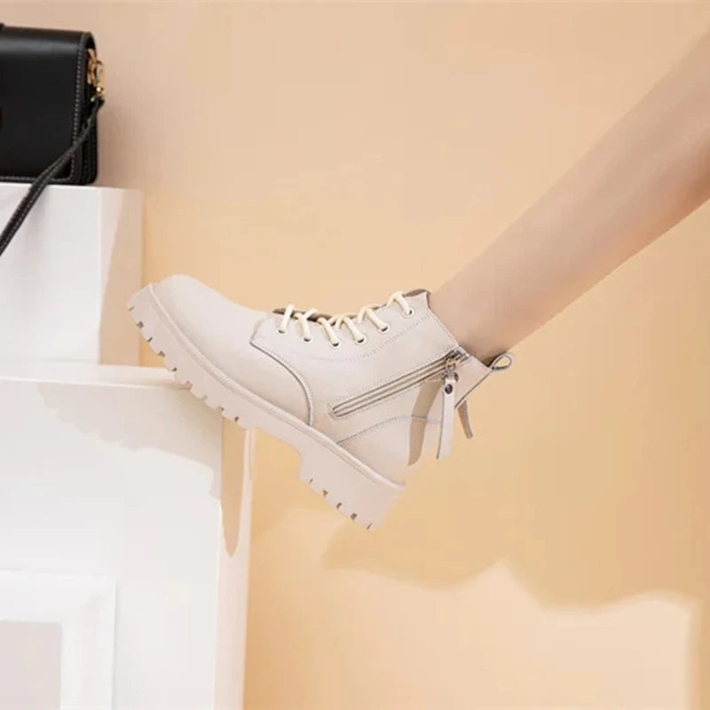 Beige Stiefeletten mit Schnürung, seitlichem Reißverschluss und Kunstfell-Applikationen.