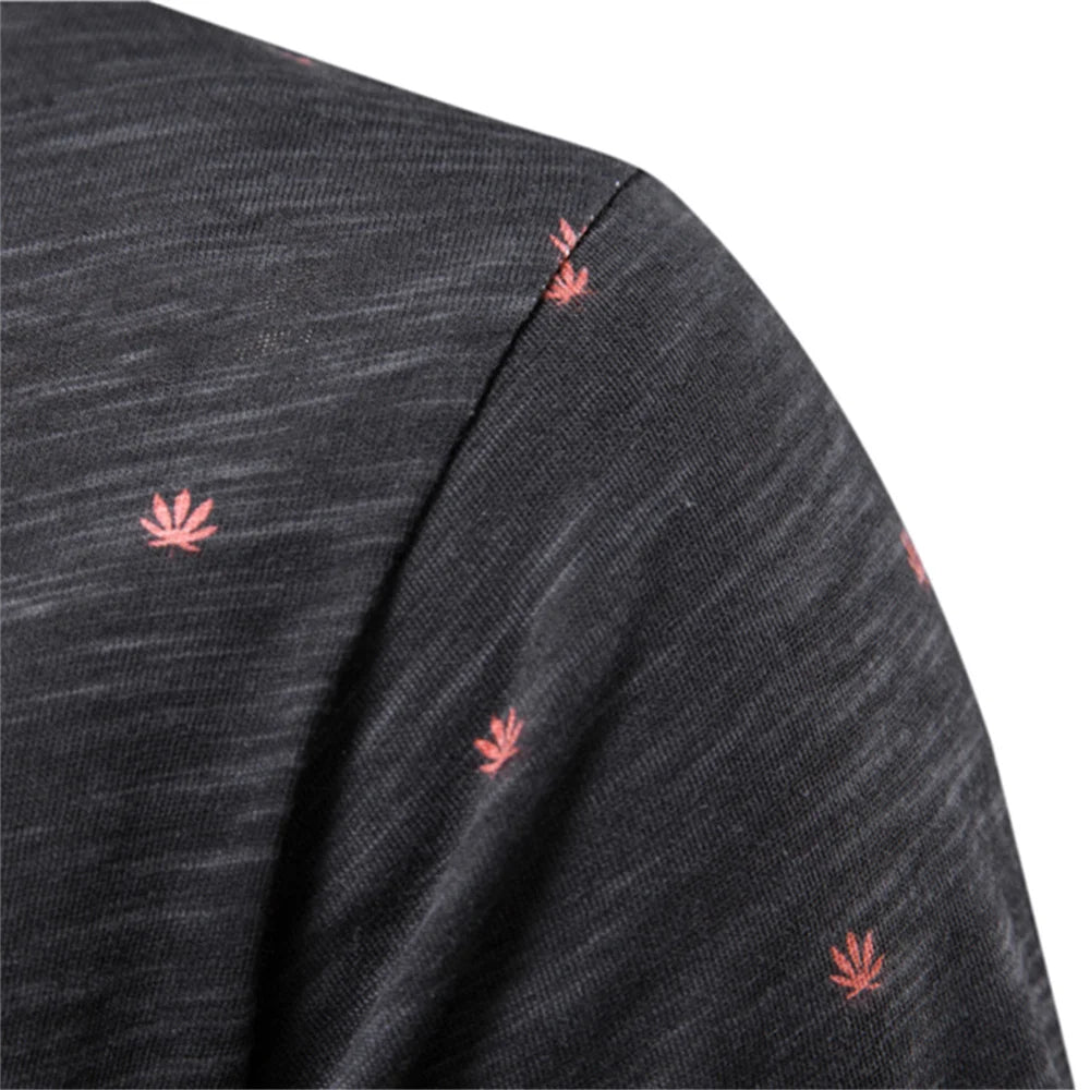 Herren-T-Shirt-Detail: dunkles Gewebe mit kleinen korallroten Blattmotiven