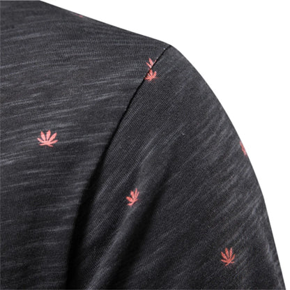 Herren-T-Shirt-Detail: dunkles Gewebe mit kleinen korallroten Blattmotiven