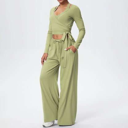 Grünes Yoga-Set mit Wickeloberteil, kurzem Saum und weiter Hose mit Bindegurt