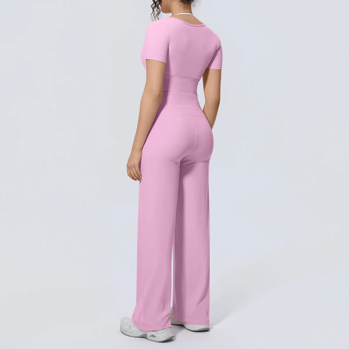 Rosa Yoga-Set: kurzes Rückenshirt und lange weite Hose