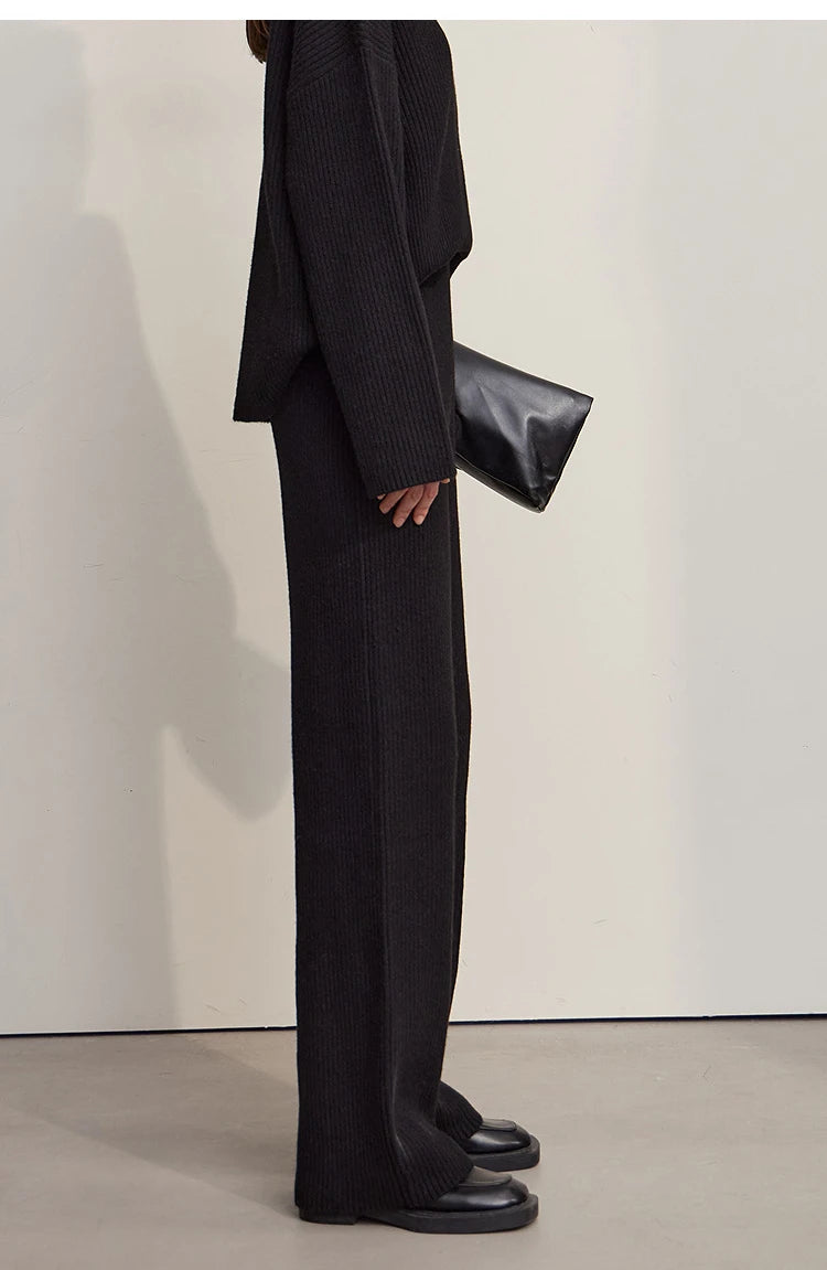 Schwarzer Rollkragenpullover und schwarze weite Hose, Seitenansicht
