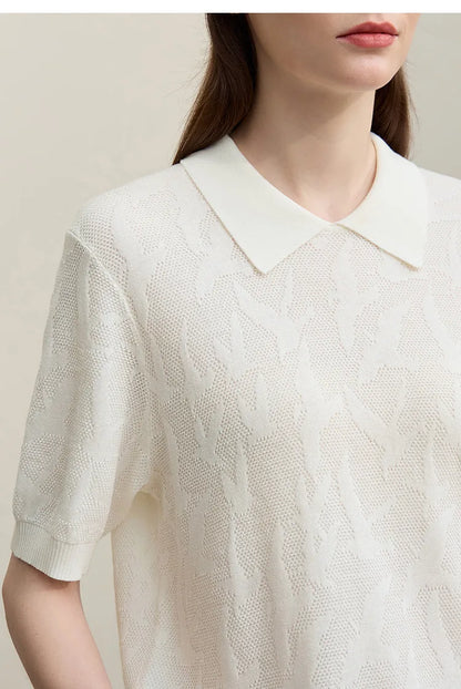 Nahaufnahme: weißer Strickpullover mit Polokragen und gemustertem Strick