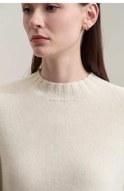 Nahaufnahme: Cremefarbener Damenpullover mit geripptem Kragen und feinem Strickstoff.