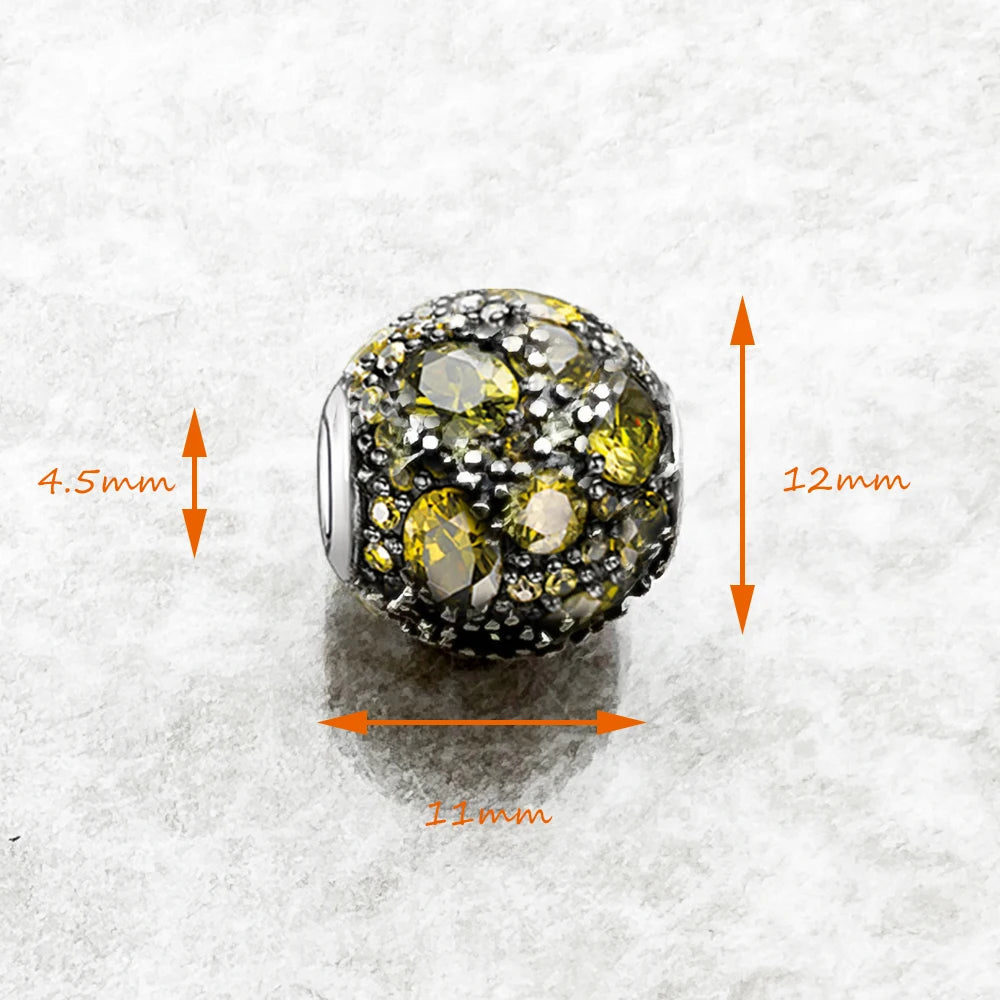 Kugeliger Charme aus 925-Sterlingsilber mit gelb-grünen und klaren Steinen, Maße: 11x12mm