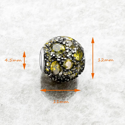 Kugeliger Charme aus 925-Sterlingsilber mit gelb-grünen und klaren Steinen, Maße: 11x12mm