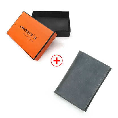 Reisepasshülle aus dunkelgrauem Echtleder neben orangefarbener Geschenkbox