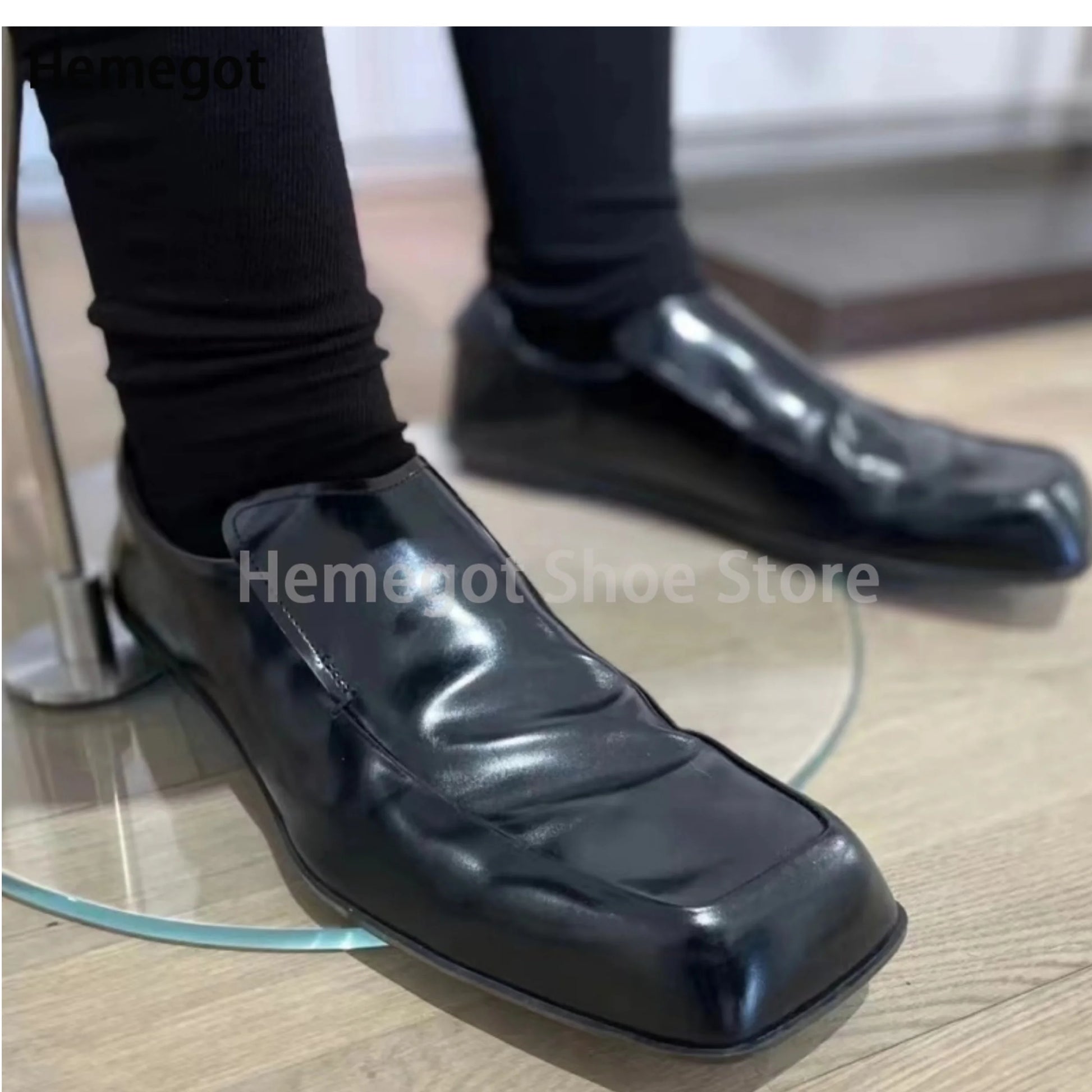 Schwarze Herren-Lederschuhe mit eckiger Spitze, flacher Slip-On-Loafer-Form.