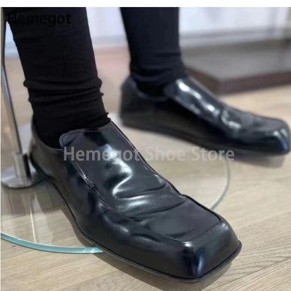 Schwarze Herren-Lederschuhe mit eckiger Spitze, flacher Slip-On-Loafer-Form.