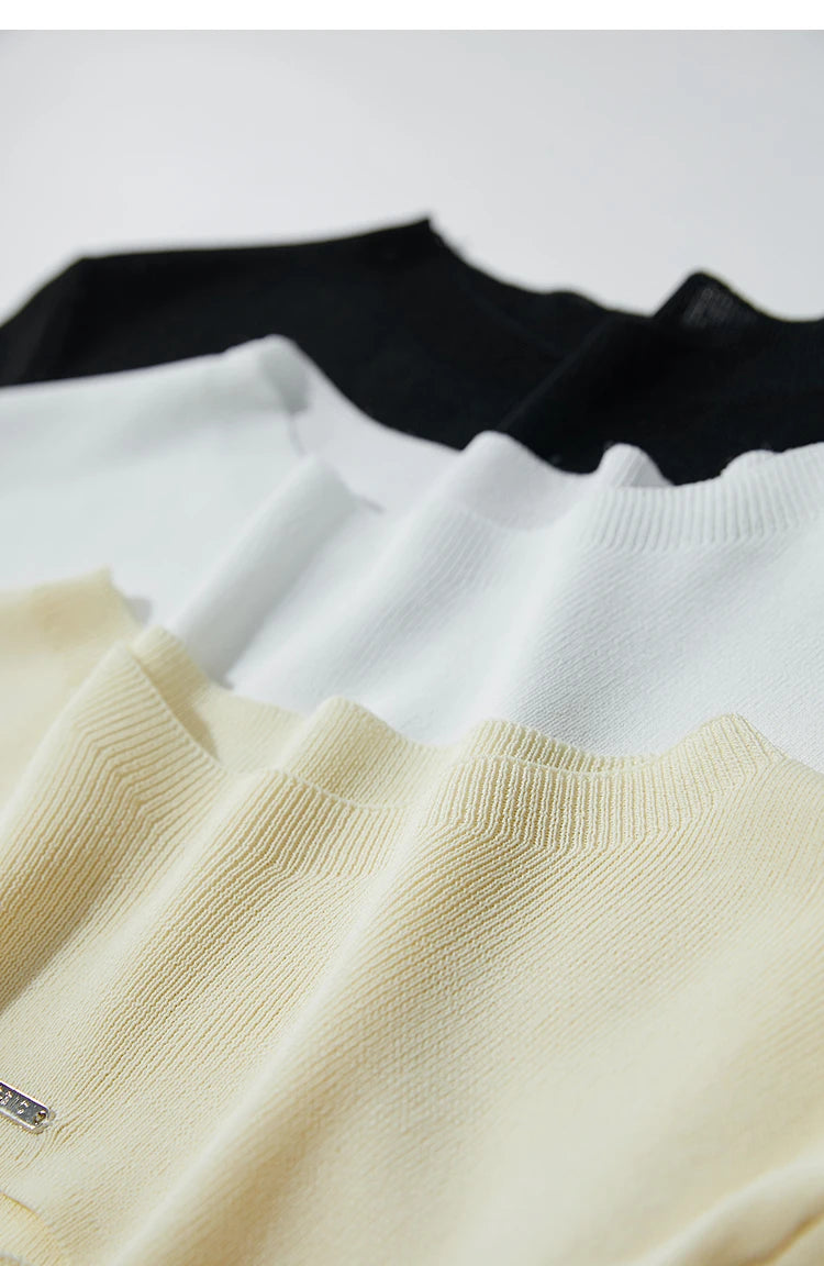 Kurzärmlige Strickpullover in hellem Gelb, Weiß und Schwarz nebeneinander