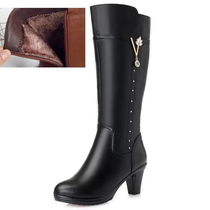 Schwarze kniehohe Damenstiefel mit Wollfutter-Ansicht und Blüten-Zieranhänger am Schaft.