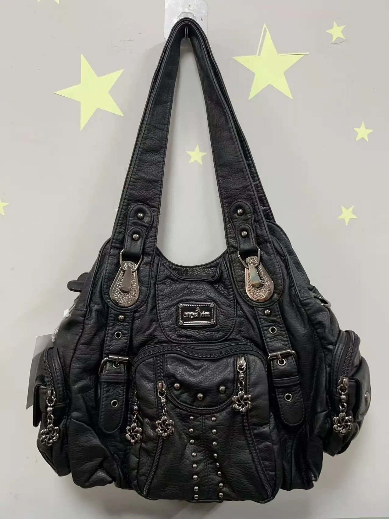 Schwarze Damenhandtasche aus Kunstleder mit Frontnieten und dekorativen Anhängern