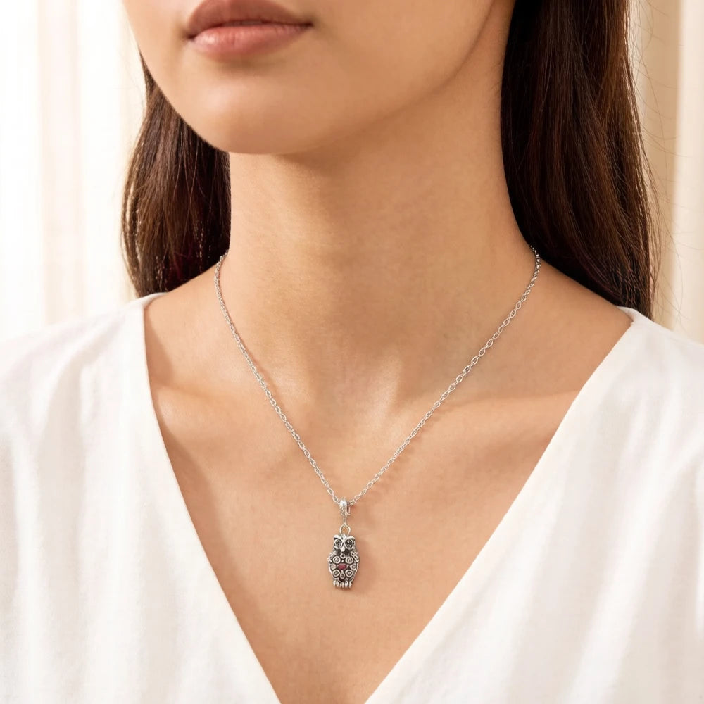 Eulen-Charm an feiner Kette am Hals, silberfarben mit farbigen Steindetails