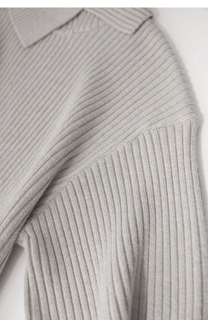Nahaufnahme: Grau-beiger Strickpullover mit gerippter Schulterpartie und Ärmelabschlüssen