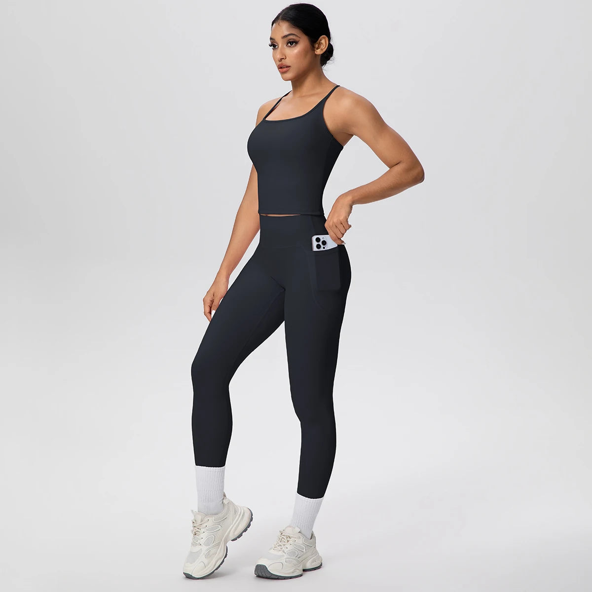 Elastisches Yoga-Set: schwarzes Trägershirt und Leggings mit hellen Einsätzen