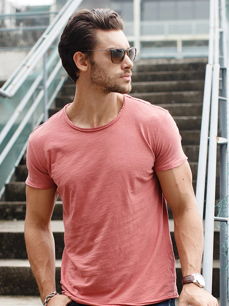 Herren-T-Shirt am Modell, kurzarm, Rundhalsausschnitt, einfarbiges rosafarbenes Shirt