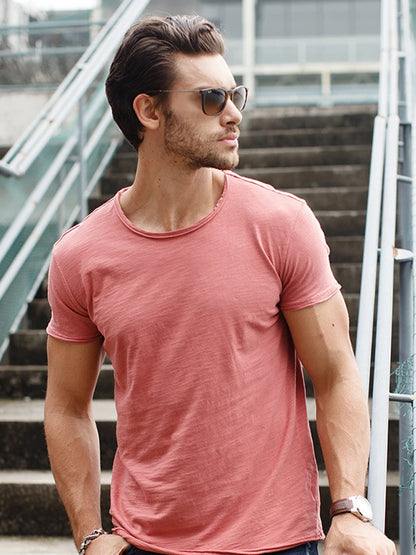 Herren-T-Shirt am Modell, kurzarm, Rundhalsausschnitt, einfarbiges rosafarbenes Shirt