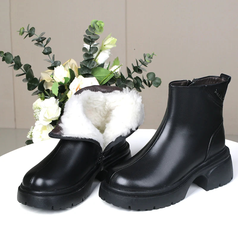 Schwarze Ankle-Boots mit weißem Fellkragen am Schaft und robuster Profilsohle