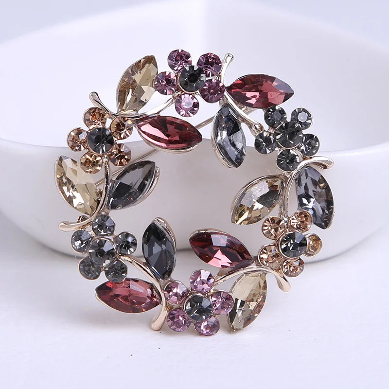 Brosche mit glitzernden Kristallen in Rosa, Braun, Grau und Schwarz, silber- und goldfarben