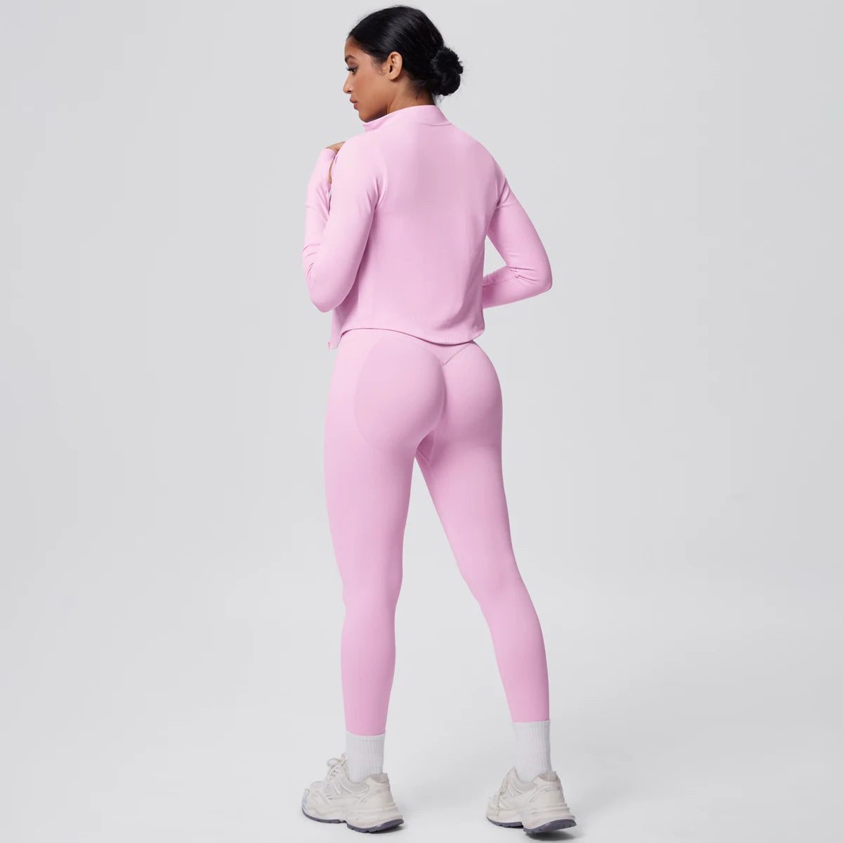 Rosa Yoga-Set mit Push-up-Top und hochtaillierter Leggings, Rückansicht im Stehen