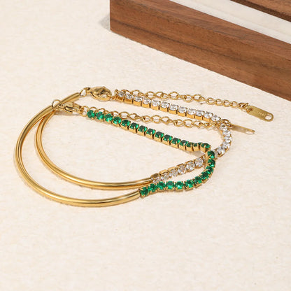 Zwei goldfarbene Tennisarmbänder mit grünen und weißen CZ-Steinen, jeweils mit Verschluss