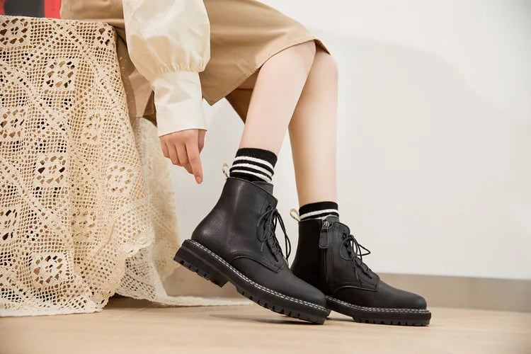 Schwarze Schnür-Stiefeletten am Bein, mit dicker profilierter Sohle und kurzem Schaft