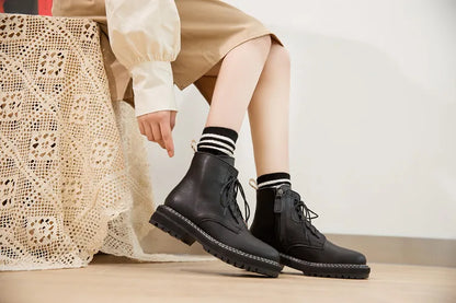 Schwarze Schnür-Stiefeletten am Bein, mit dicker profilierter Sohle und kurzem Schaft