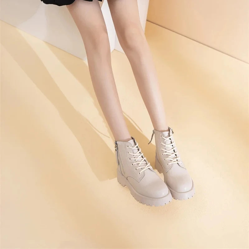 Beige Stiefeletten mit Schnürung und dicker Profilsohle, Kunstfellbesatz am Schaft.
