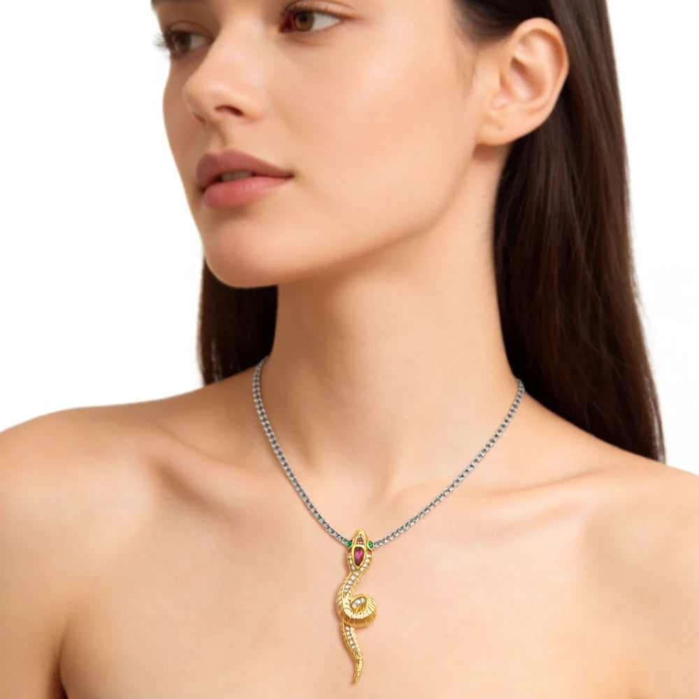 Schlangen-Anhänger goldfarben mit rosa Stein, auf dunkler Gliederkette am Hals