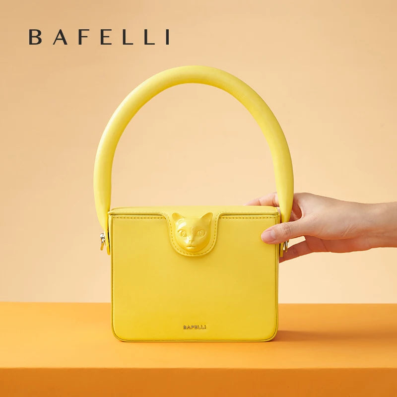 Gelbe Abendtasche aus Echtleder mit Henkel, von Hand seitlich gehalten