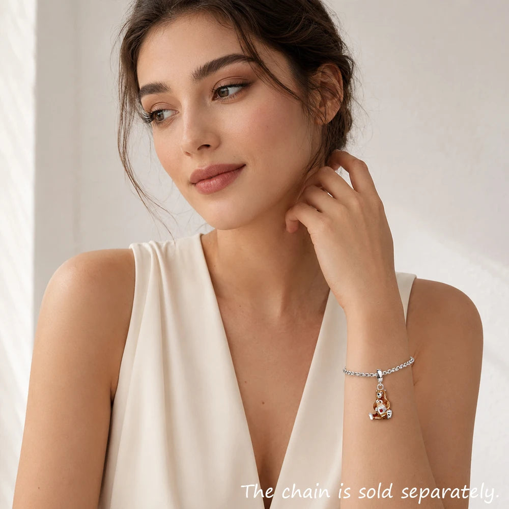 Bär-Charm am silbernen Armband mit Herz-Anhänger, Detail am Handgelenk