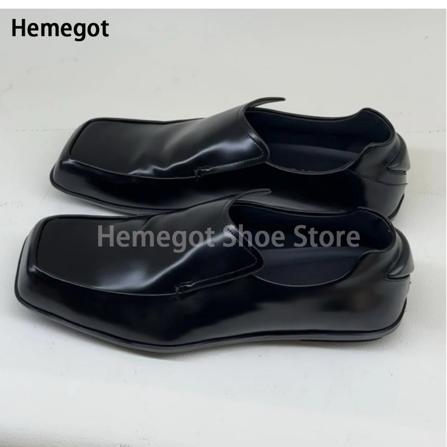 Schwarze Lederschuhe, flacher Slip-On-Loafer mit eckiger Kappe, Vorderansicht.