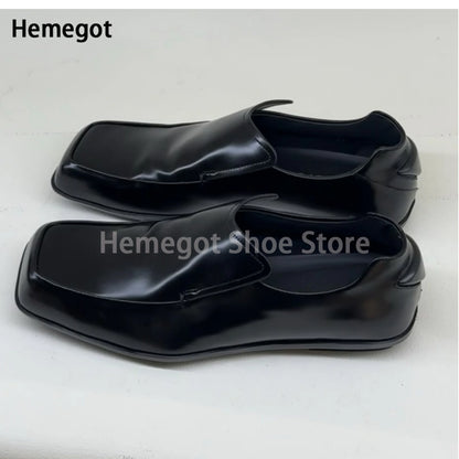 Schwarze Lederschuhe, flacher Slip-On-Loafer mit eckiger Kappe, Vorderansicht.