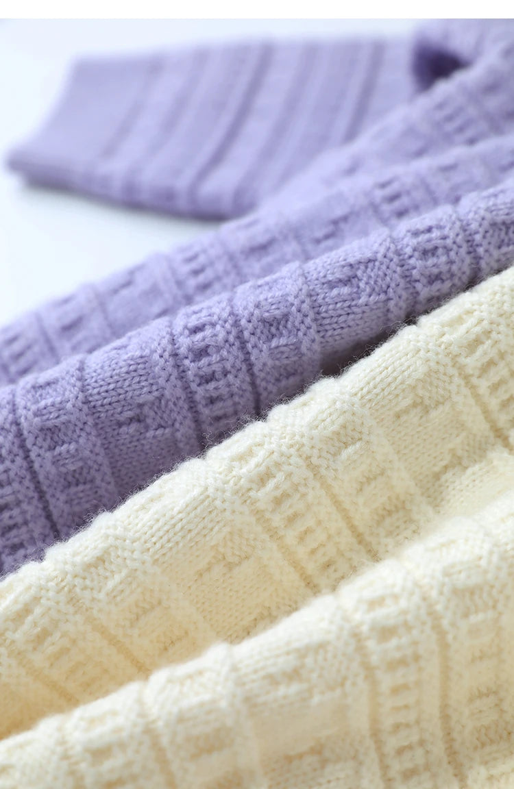 Ärmelbündchen im Strick, beiger und helllila Pullover mit Rautenstruktur