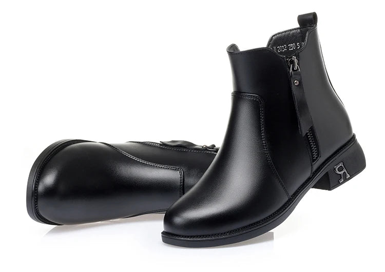 Schwarze Stiefelette mit kurzem Schaft, seitlichem Reißverschluss und Blockabsatz.