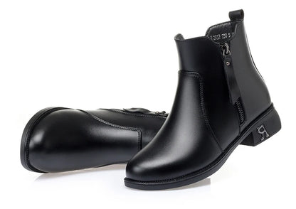 Schwarze Stiefelette mit kurzem Schaft, seitlichem Reißverschluss und Blockabsatz.