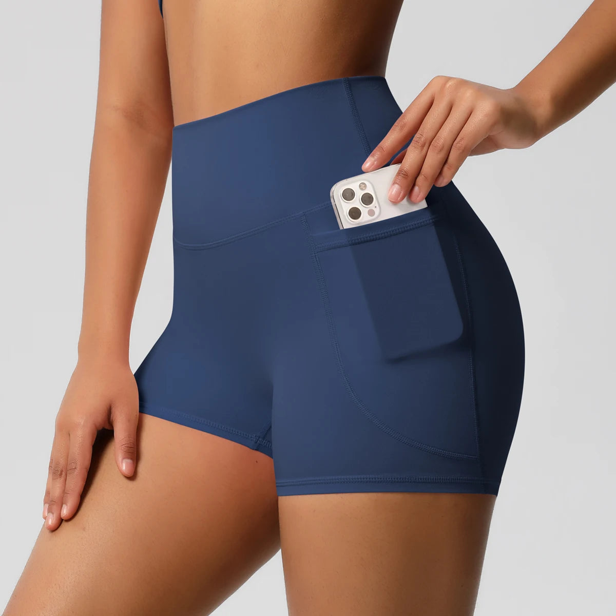 Damen-Yogashorts hohe Taille mit Seitentaschen, dunkelblau, mit eingestecktem Handy