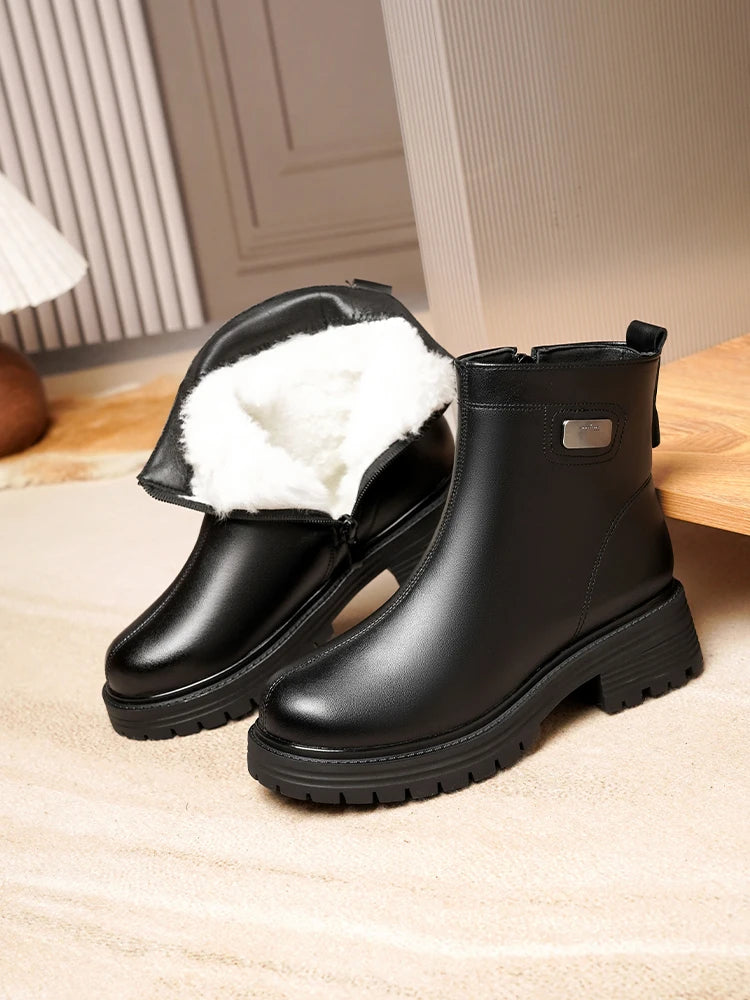 Schwarze Stiefeletten mit Lammfellfutter im Schaft und Profilsohle, seitliche Lasche