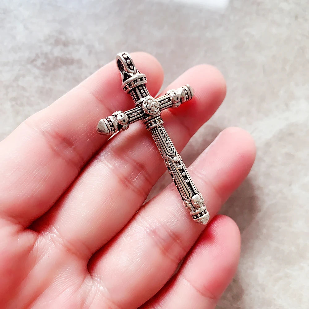 Kreuz-Anhänger aus 925 Sterling Silber mit Schädel-Relief, in der Hand gehalten