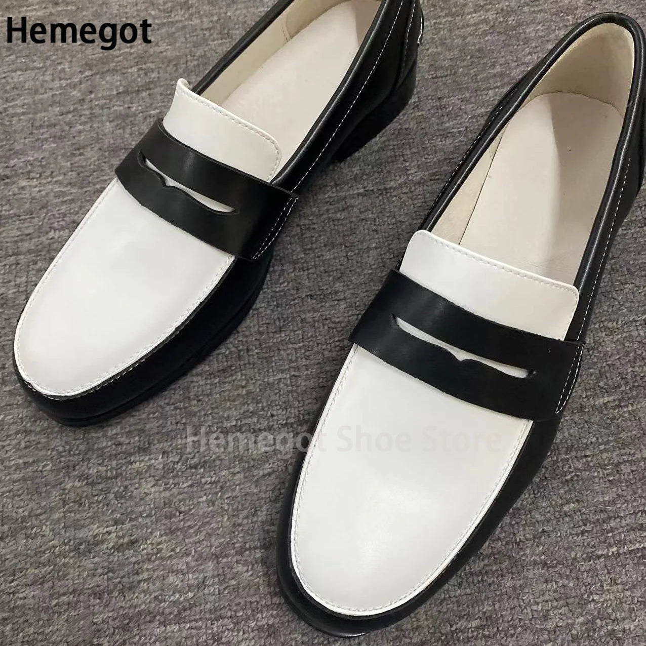 Weiße Loafer mit schwarzem Riemen, Paaransicht, Lederoptik, Schlupfschuh.