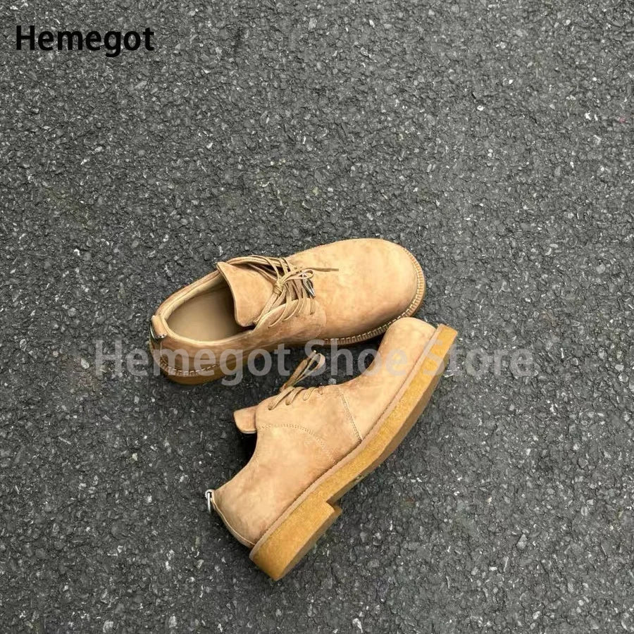 Beige Wildleder-Derby-Schuhe mit Schnürung, runder Kappe und flacher Plateau-Sohle.