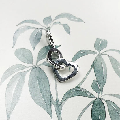 Detailansicht: silberner Herz-Charm aus 925 Sterlingsilber mit zwei ineinander verschlungenen Herzen