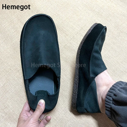 Herren-Slipper aus dunklem Leder mit Schlupföffnung, seitlicher Naht und flacher Sohle