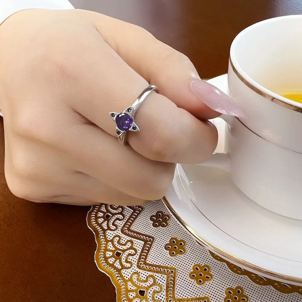 Ring am Finger: 925 Silber mit violettem Stein und grünen Schmuckelementen
