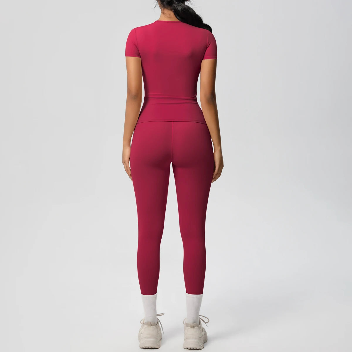 Burgunderrotes Sport-Set: Crop-Top und Leggings, eng geschnitten, 3/4-Länge, weißer Beinabschluss.