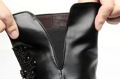 Schwarzer Overknee-Stiefel mit Zierschnalle auf dem Schaft und eingesetztem Träger